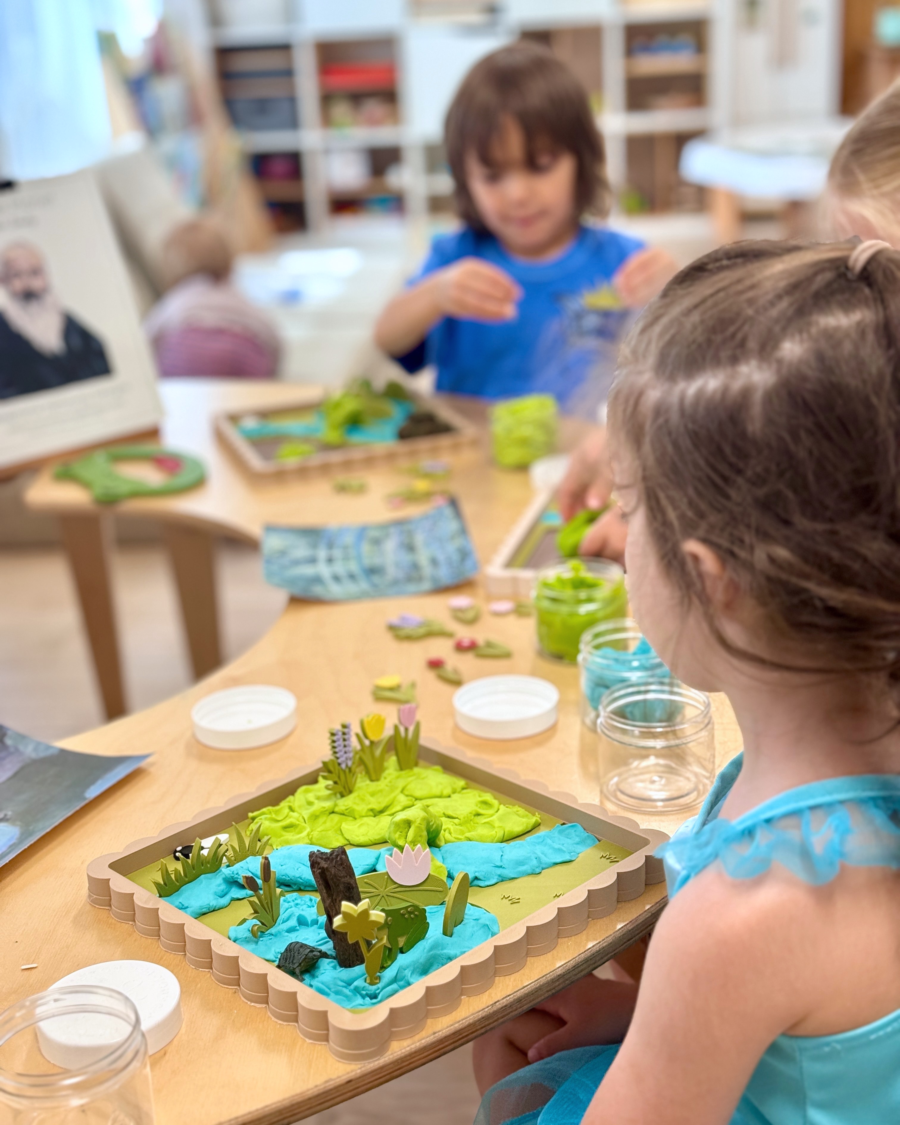 Children creating a hands-on pond scene during a classroom investigation