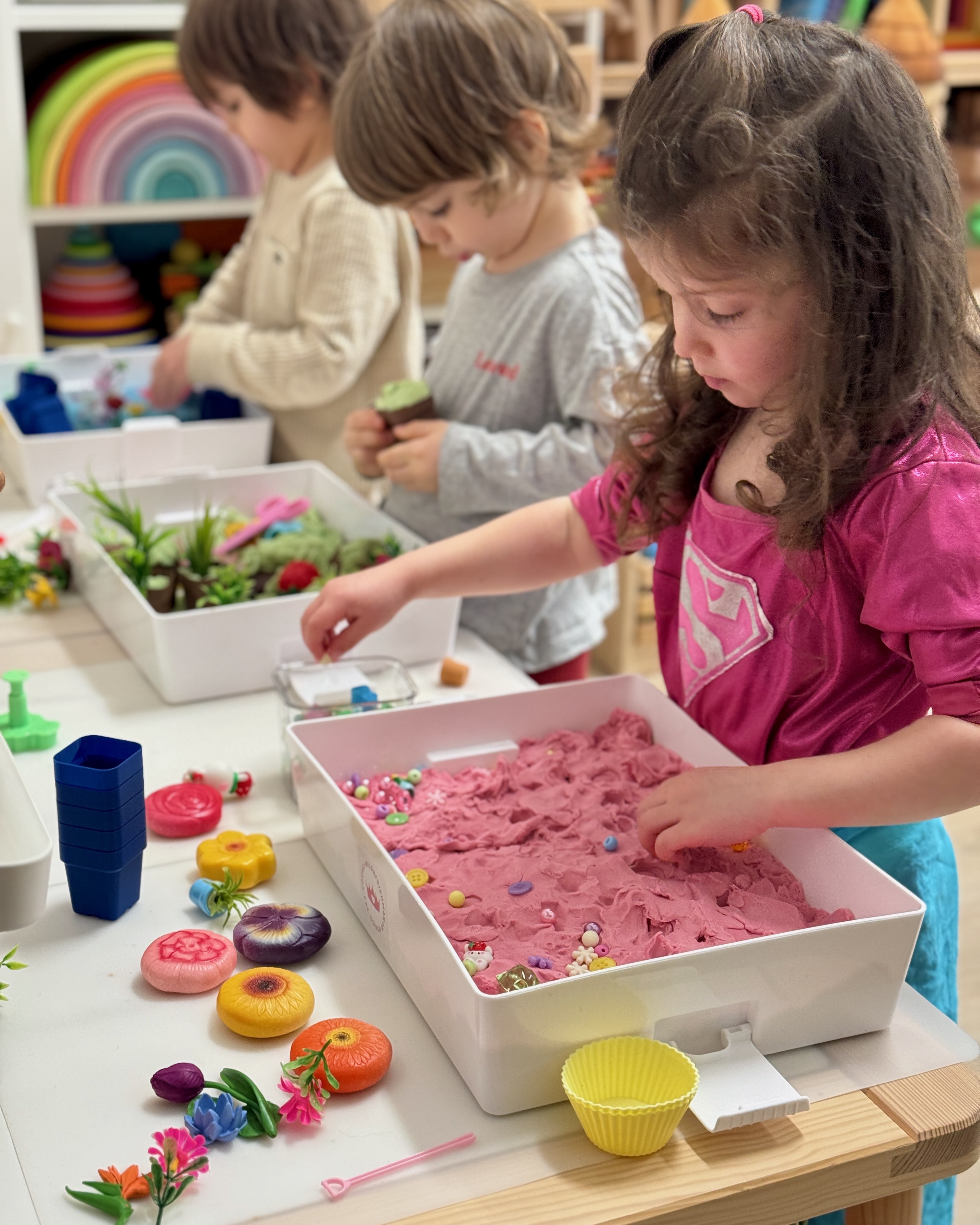 Children exploring tactile materials in colorful sensory bins