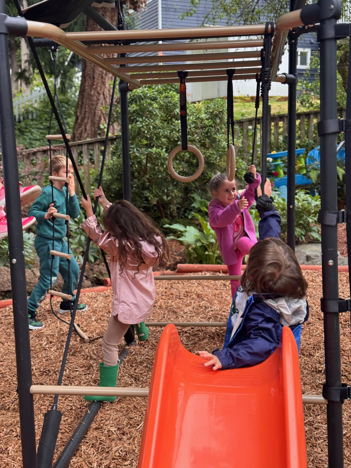 Children climbing and playing together on outdoor playground equipment
