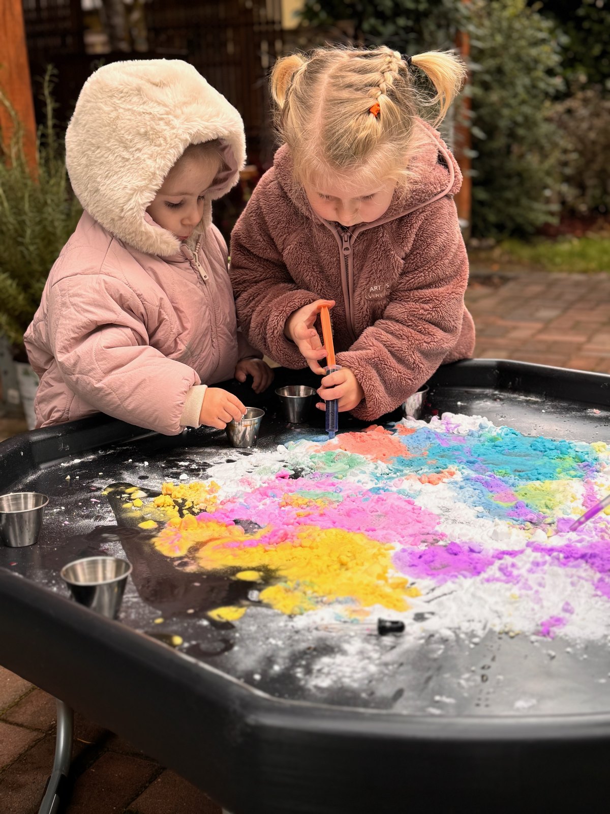 Children creating colorful process art with open-ended materials outdoors