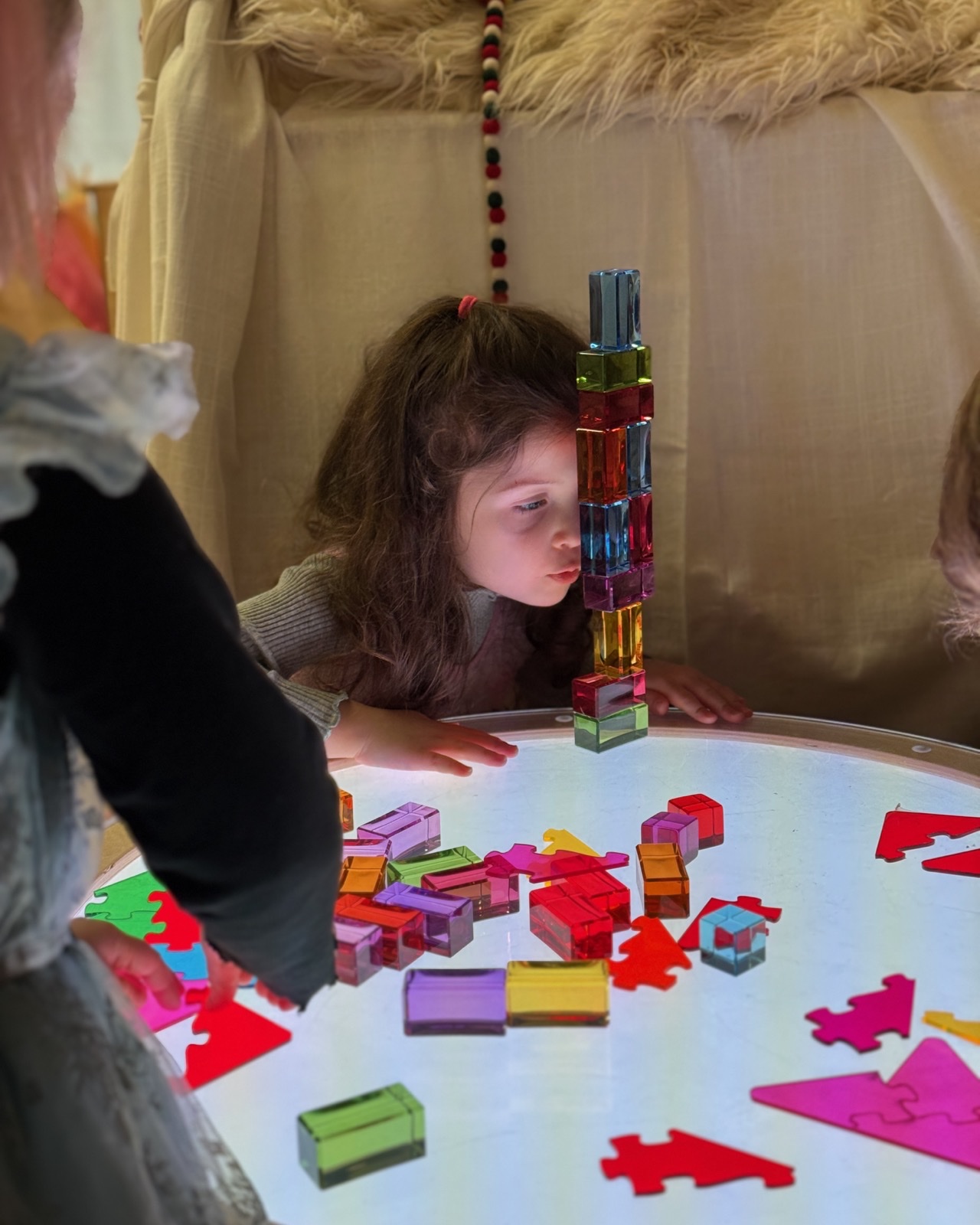 A child investigating translucent blocks on a light table