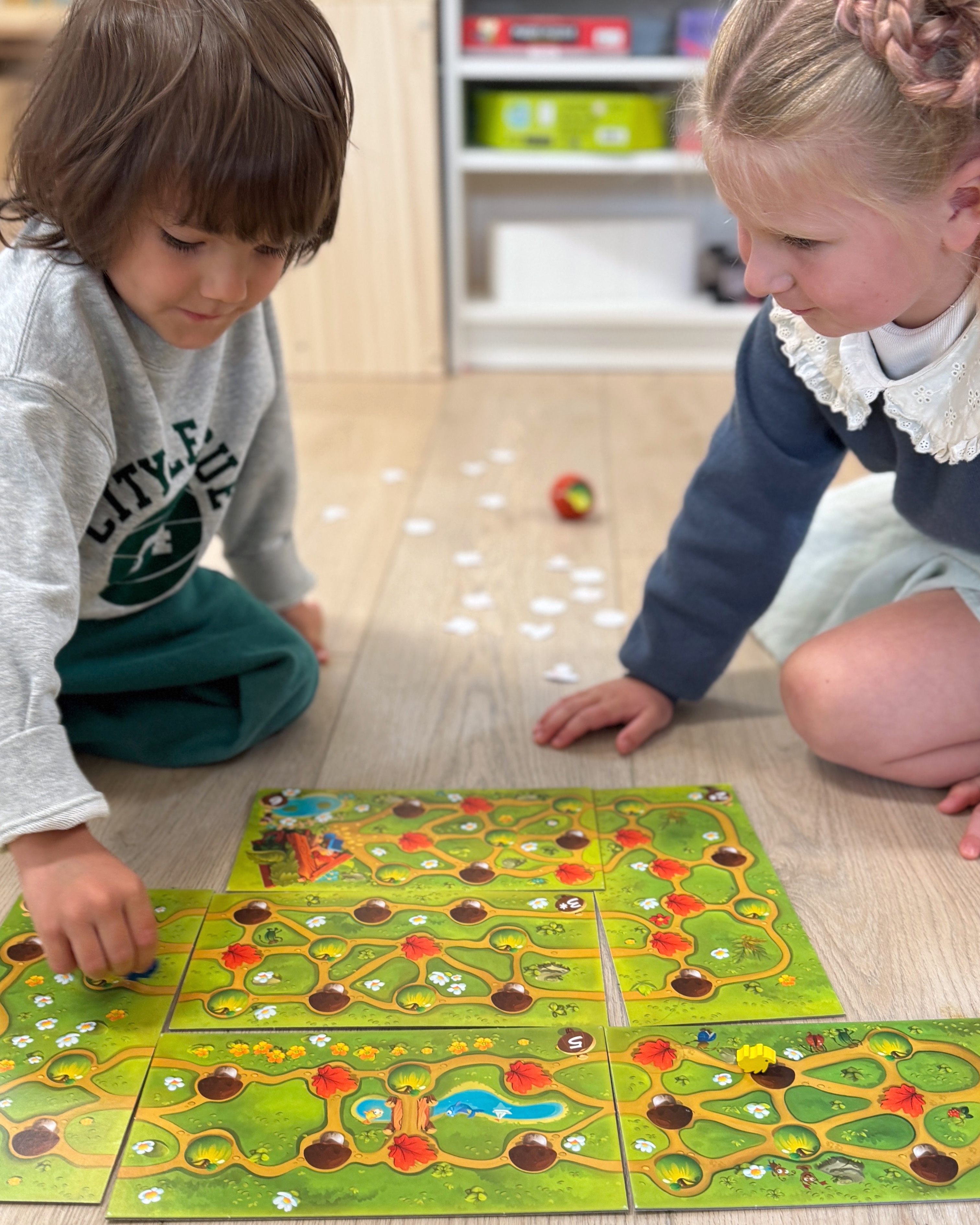 Two children collaborating over a classroom learning game