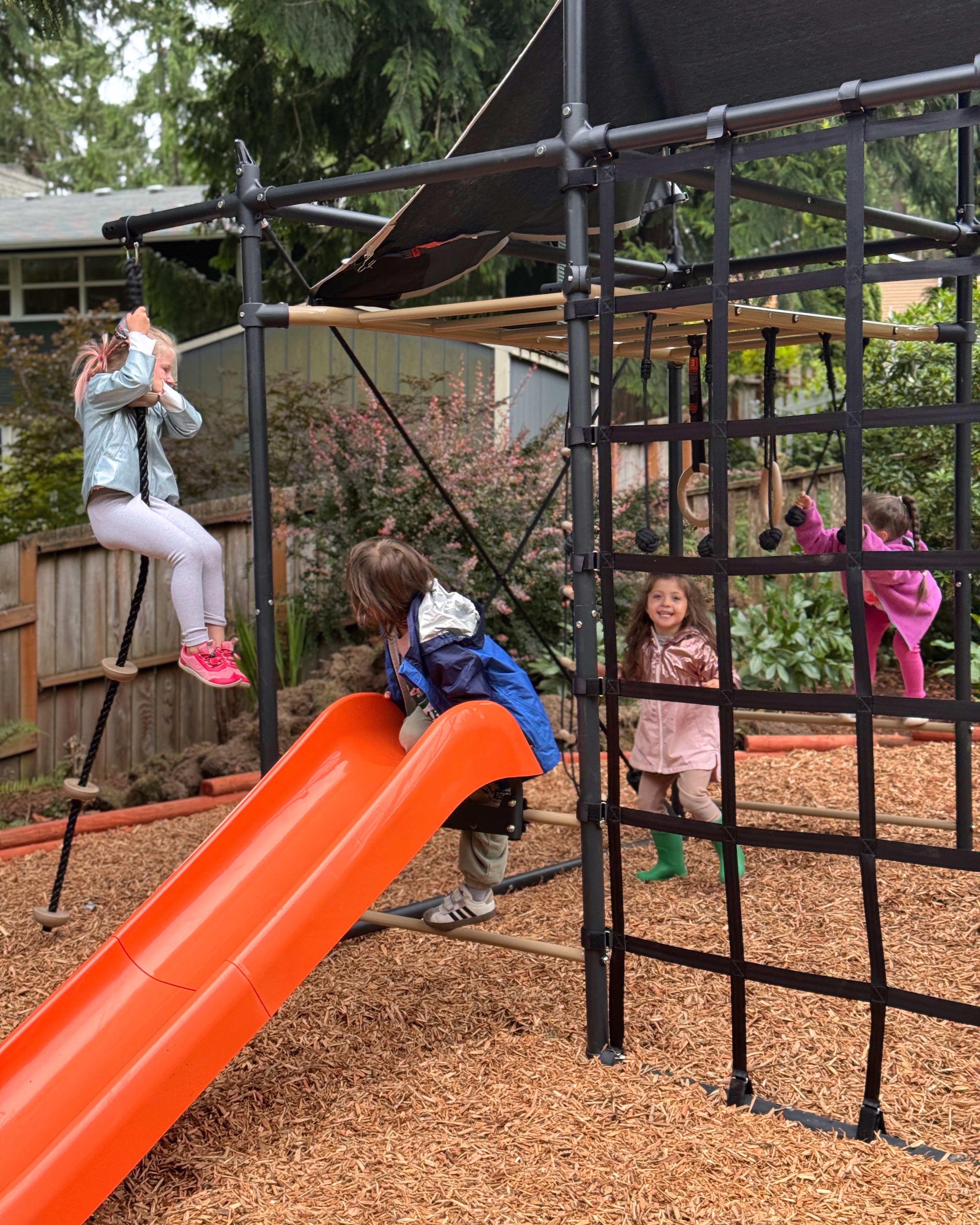 Children climbing, balancing, and playing together during outdoor recess