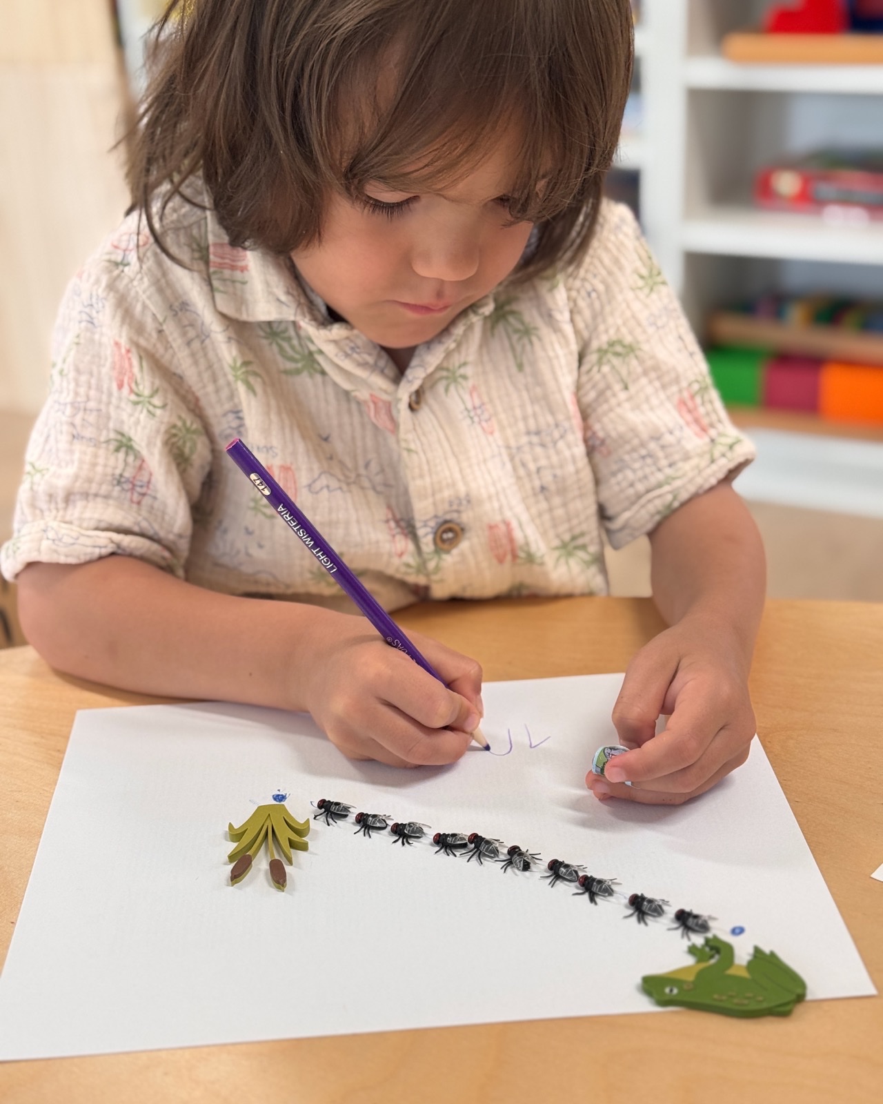 A child practicing writing during the English Kindergarten Readiness program